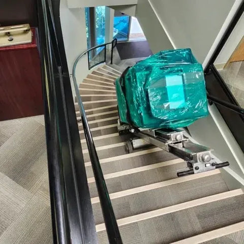 A protected copier being transported up stairs with our stair climbing equipment